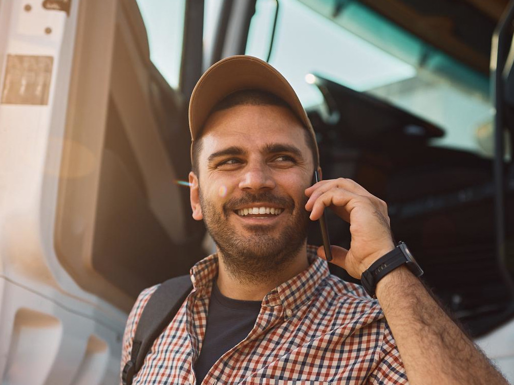 Truck driver happy about finding a parking space – Stress-free parking search with Happy Trucker